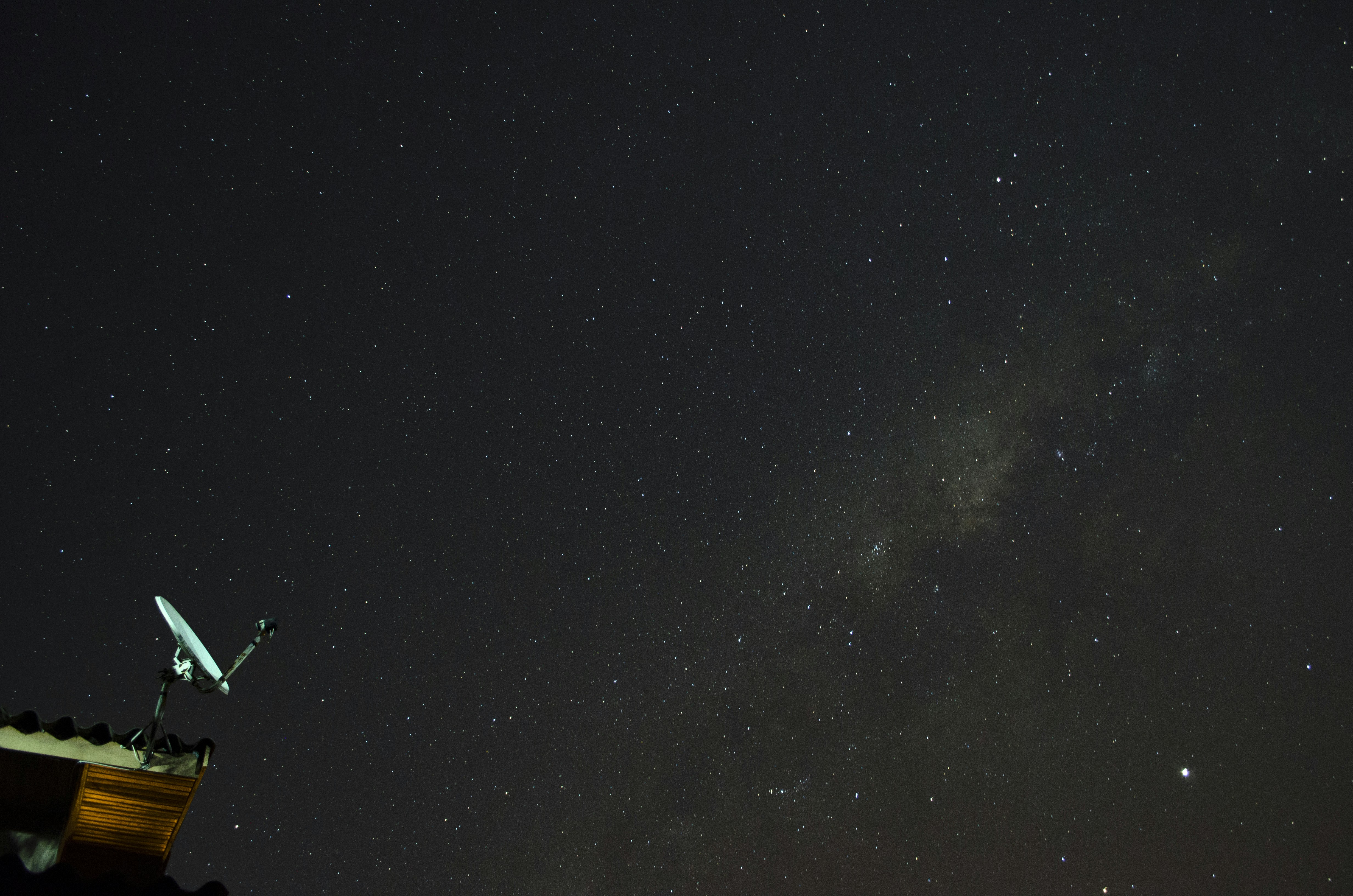 a telescope on top of a building under a night sky