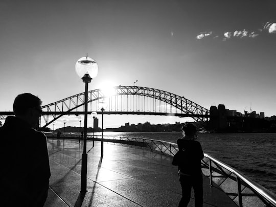 two person near bridge and body of water grey-scale photography in Sydney Harbour Bridge Australia