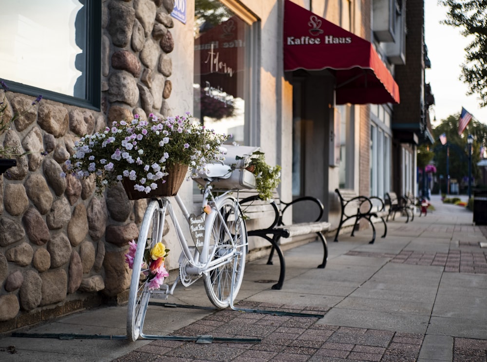 white bicycle parked standing near store