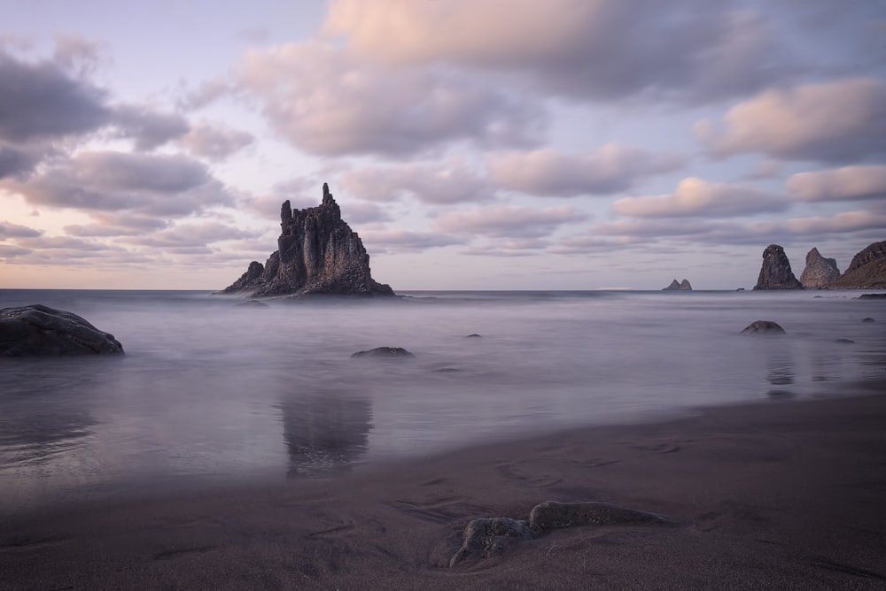 brown rock on body of water