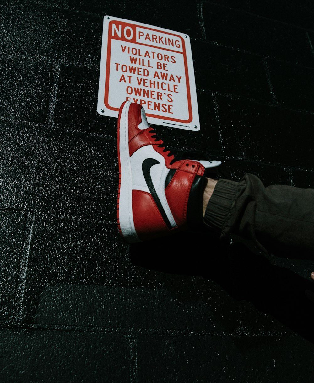 person wearing red and white Nike sneaker