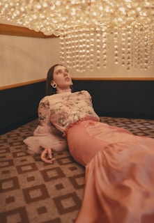 A woman lounging in a chic living room, draped in a flowing silk blouse from the latest collection.