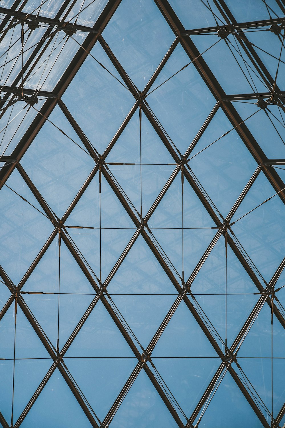 Un primer plano de un edificio de cristal con un cielo azul en el fondo