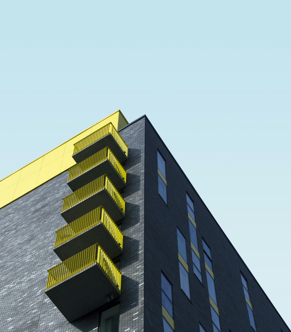 edifício amarelo e preto sob o céu azul durante o dia