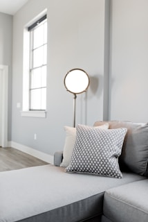 A minimalist living room illuminated by subtle, modern lighting fixtures in grey hues