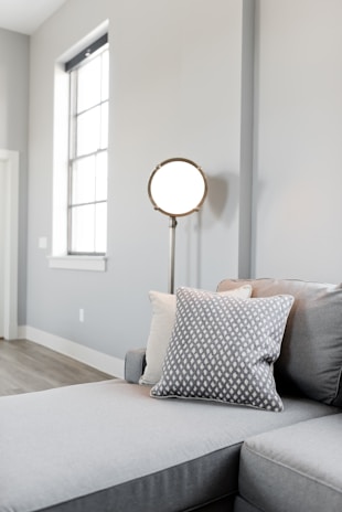 A minimalist living room illuminated by subtle, modern lighting fixtures in grey hues