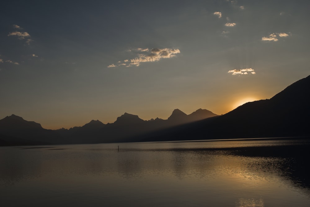 silhouette of mountain and calm water