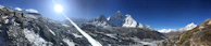 Majestic sunlit mountain peaks with hikers enjoying the panoramic view.