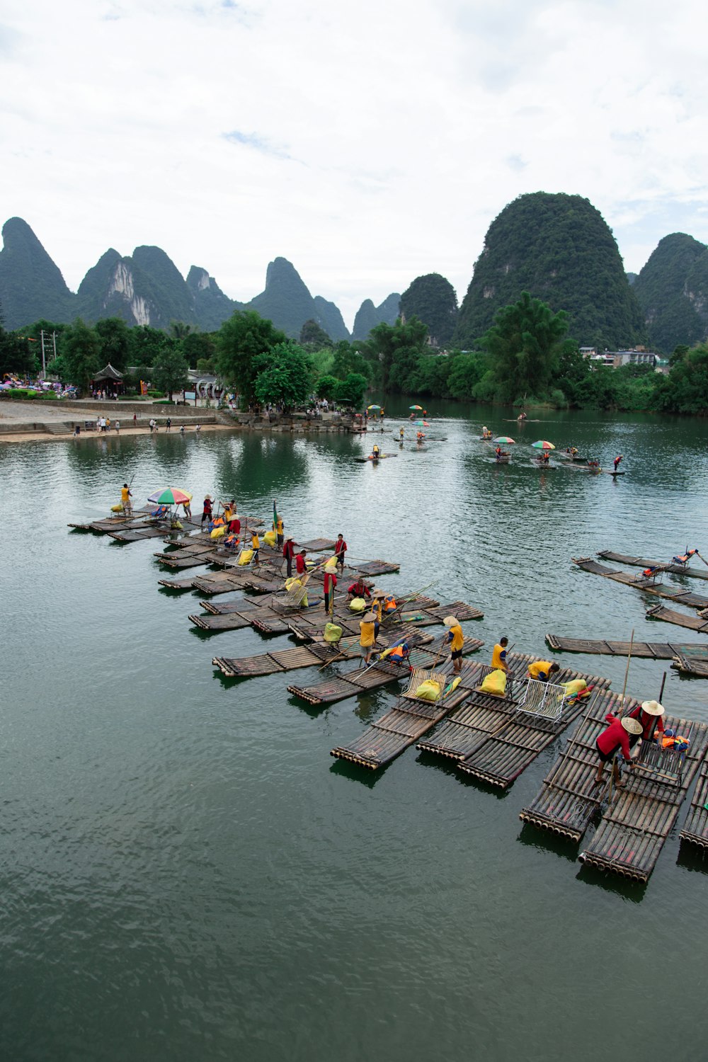 Eine Gruppe von Menschen, die auf Holzflößen in einem Gewässer stehen