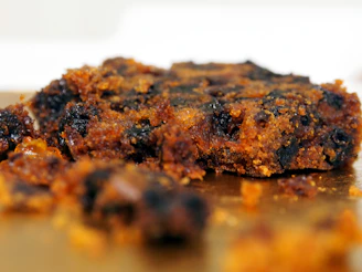 Close-up of a rich, moist dry fruit cake adorned with colorful nuts and dried fruits.