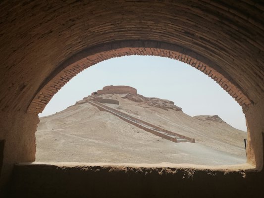 A Zoroastrian tower of silence seen through an arch — Yazd, Iran