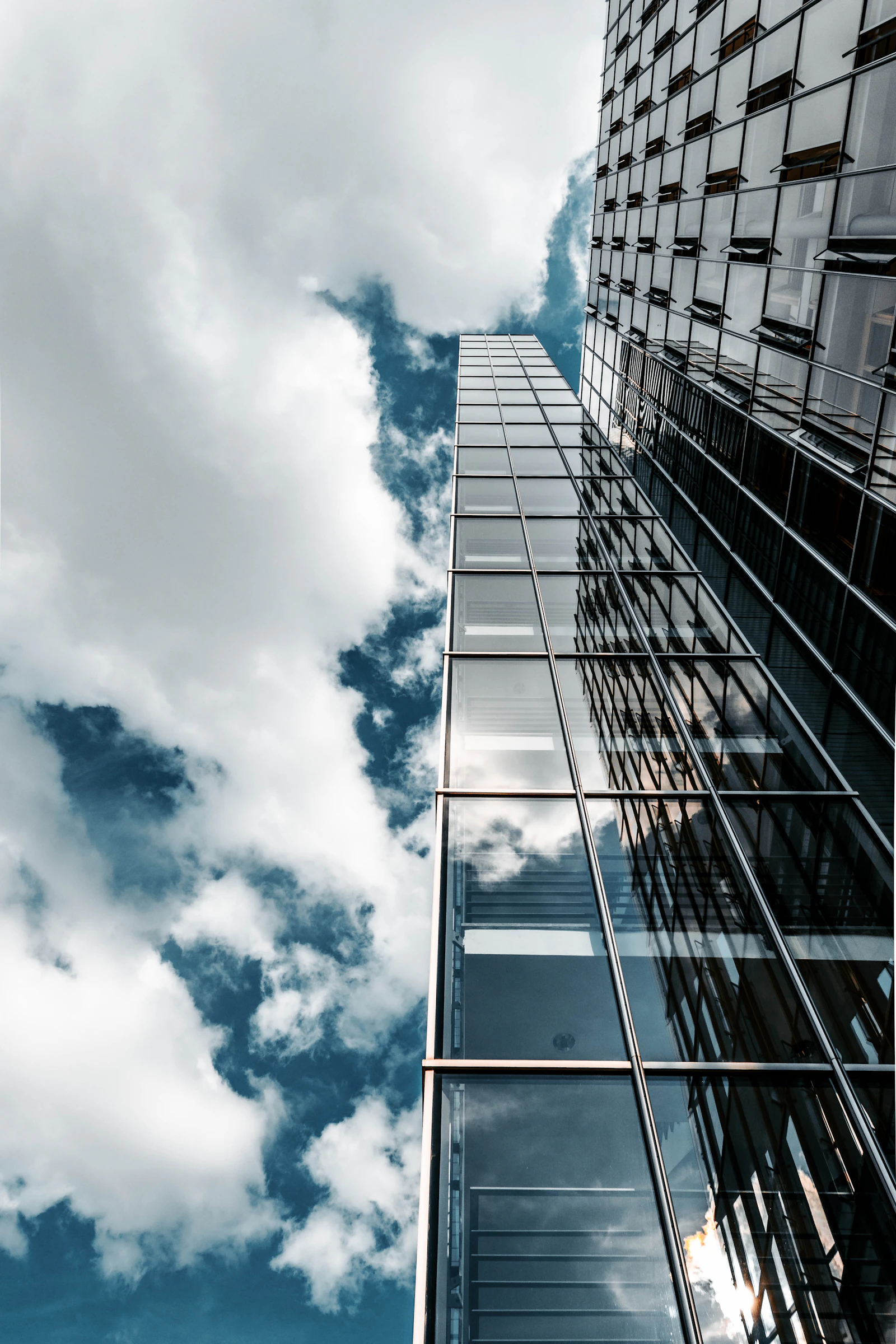 Clouds reflected in the glass facade of an office tower.