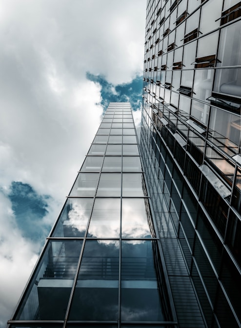 low angle photography of high rise building under cloudy sky