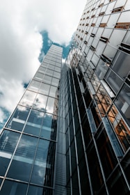 low angle photography of glass building under cloudy sky