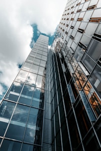 low angle photography of glass building under cloudy sky
