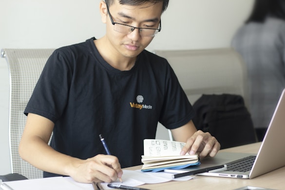 man writing on paper