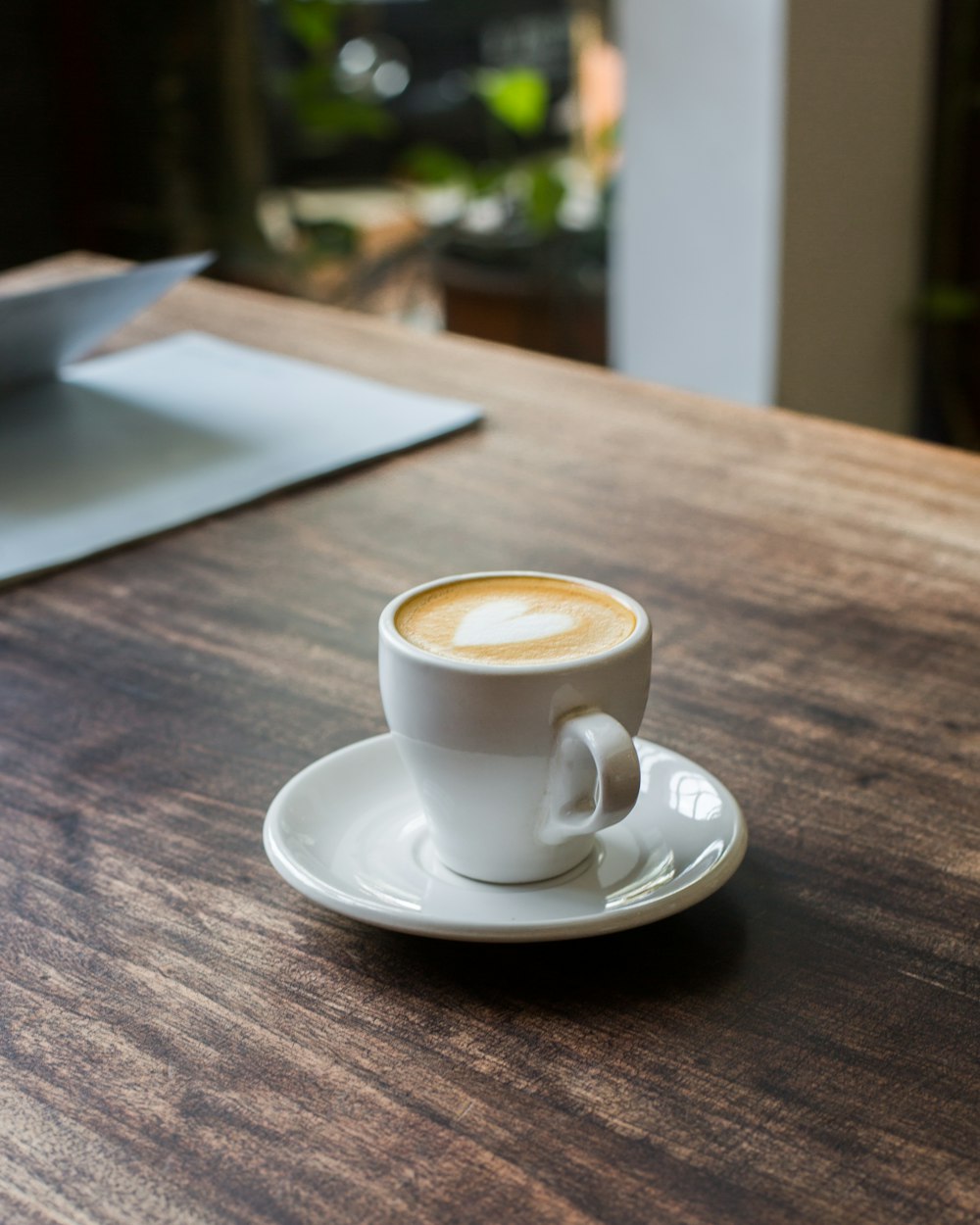 white ceramic teacup with creamy coffee