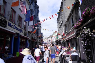 A lively street scene outside Windsor Castle with visitors and colorful flags fluttering