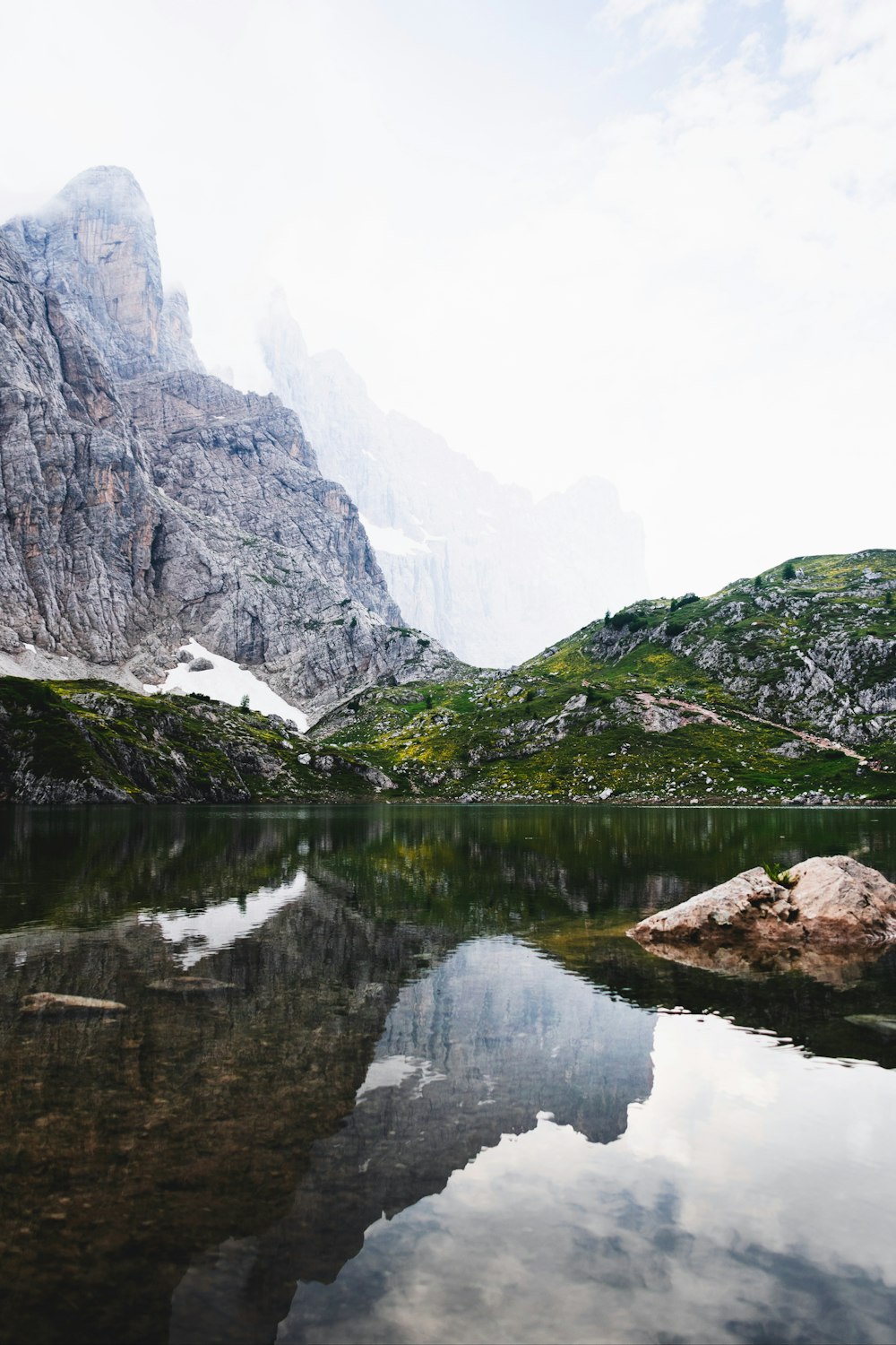 calm body of water near mountain