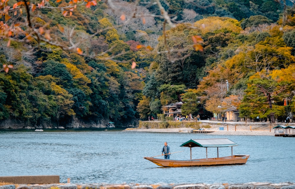 person riding on boat surrounded by body of water during daytime