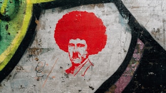 A classic black and white stencil of 'kilroy was here' graffiti with the iconic doodle of a bald man peeking over a wall.