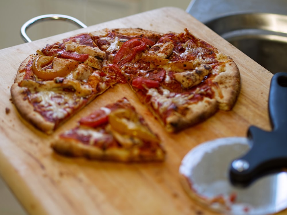 pizza on a wooden tray with wheel pizza cutter