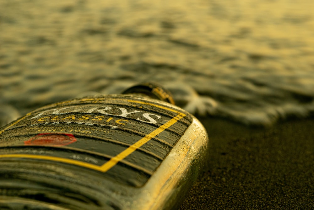 a close up of a bottle on the beach