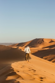 man walking on desert during daytime