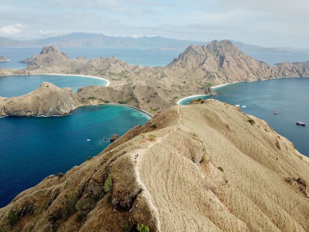 Montañas marrones junto al cuerpo de agua durante el día