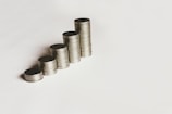 Stacks of coins arranged in ascending order on a white surface.
