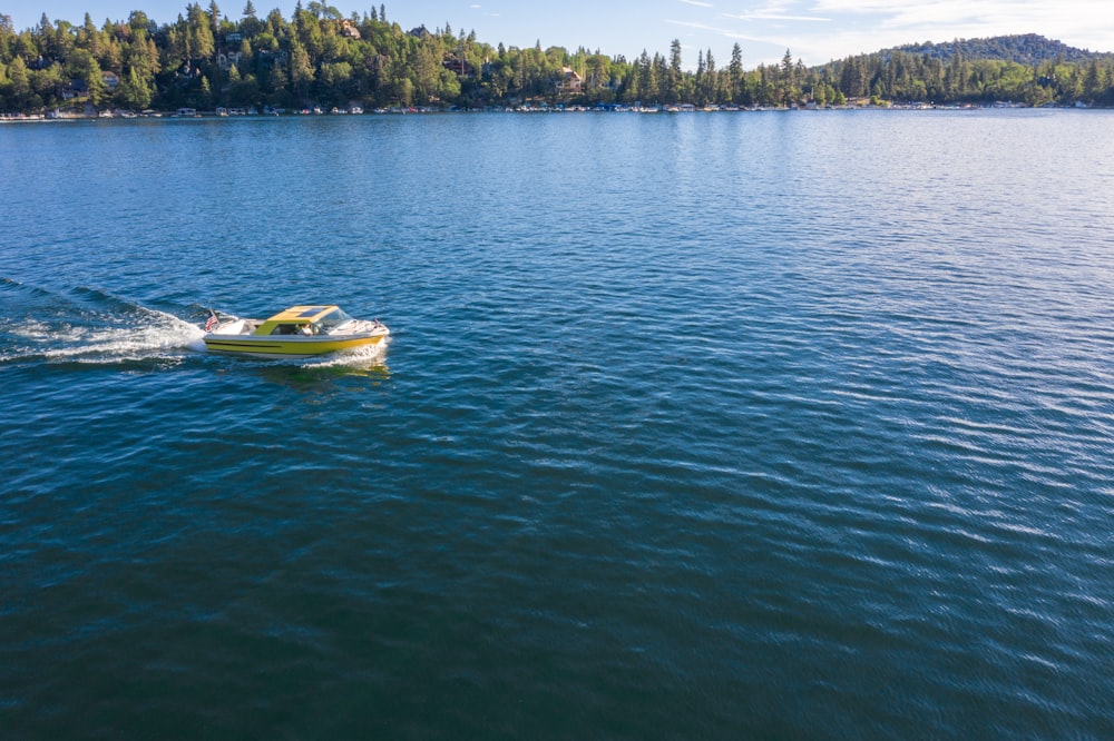 yellow and white boat on body of water at daytime