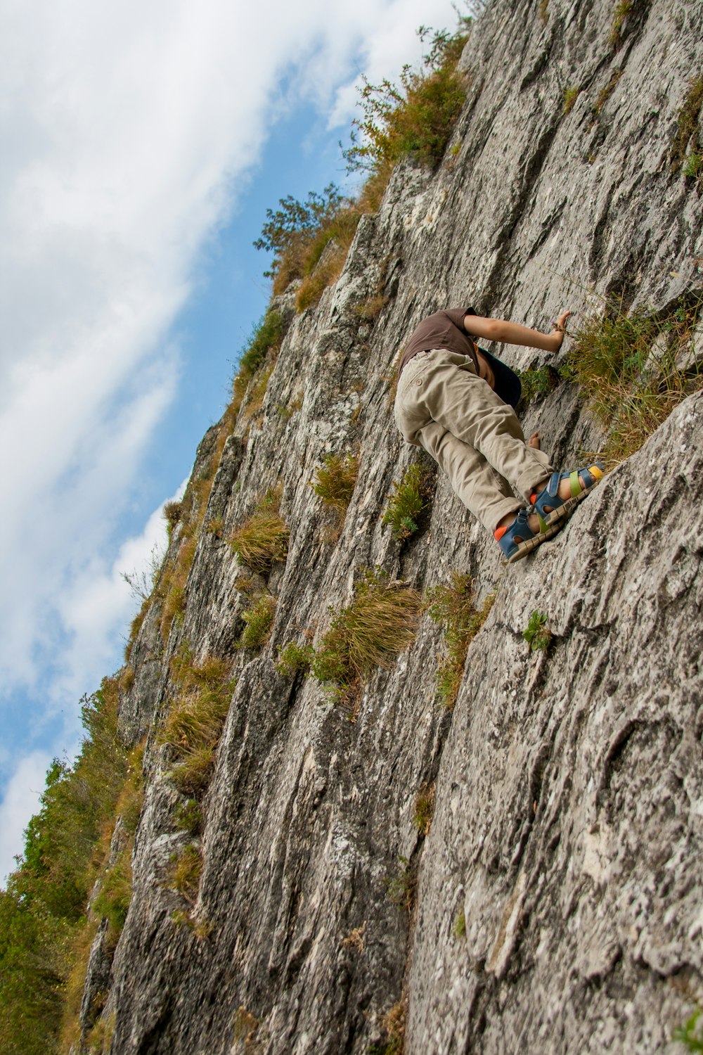 person climbing on cliff during day time