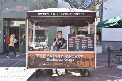 A food truck serving golden crêpes and galettes to happy customers outdoors.