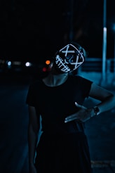 femme portant un tshirt noir et un masque onlyfans