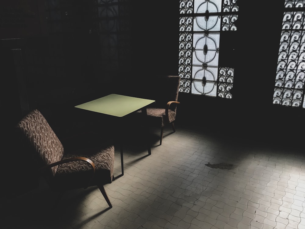 two chairs and a table in a dark room