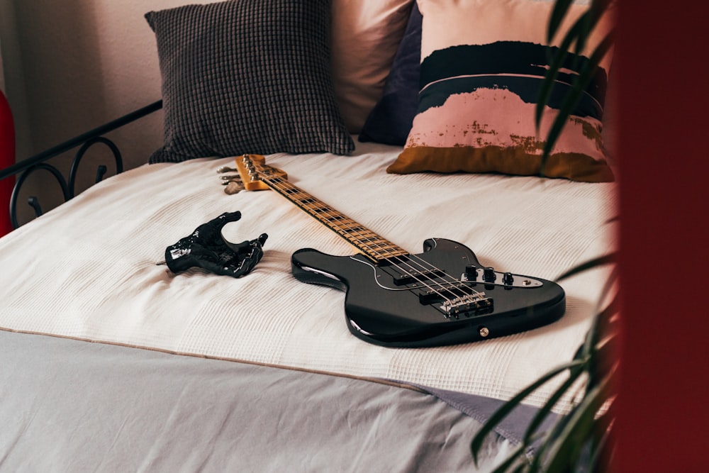 Schwarze Bassgitarre auf dem Bett
