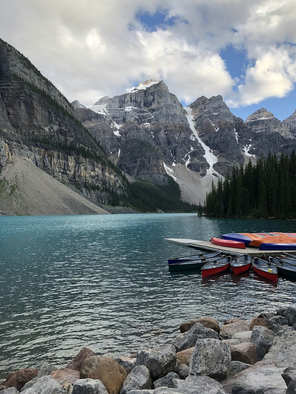 assorted-color canoe beside dock