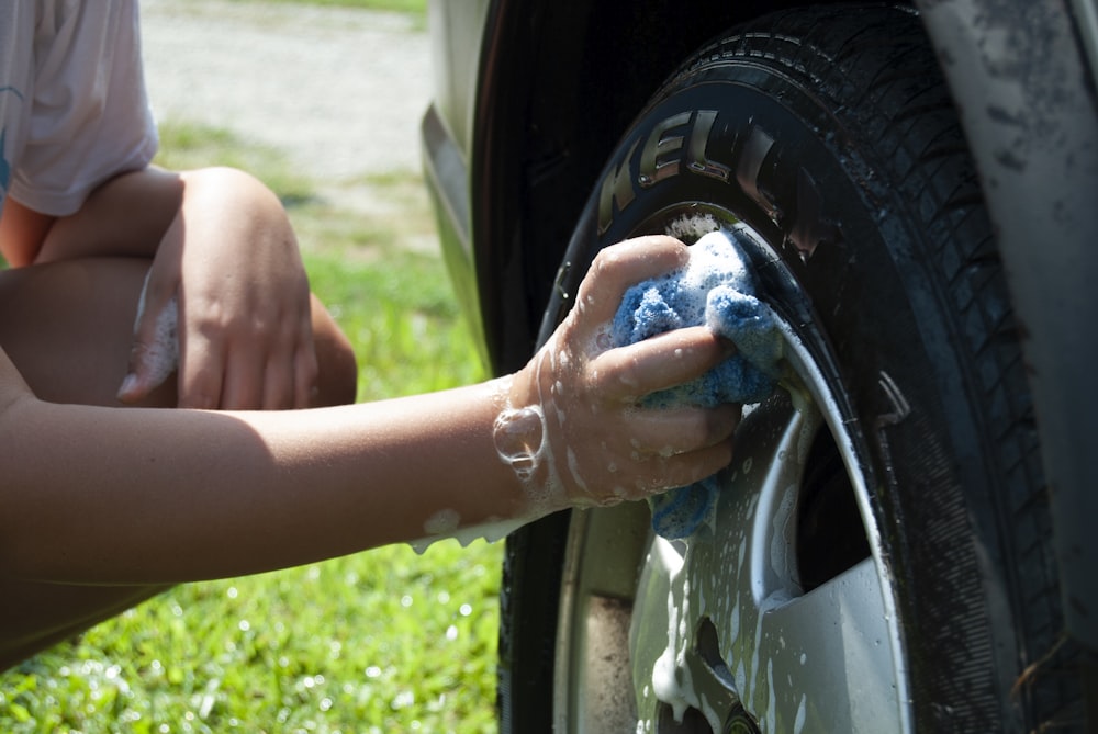 person washing vehicle tire