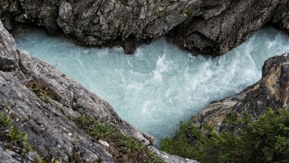 river water flowing under rocky hills