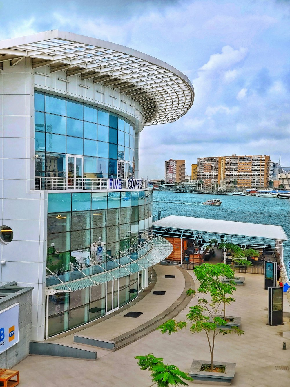 white and blue glass building near body of water at daytime