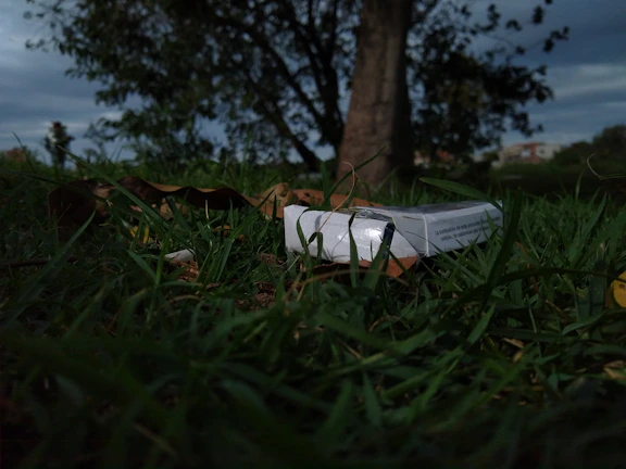 Close-up of a person happily crushing a cigarette pack outdoors
