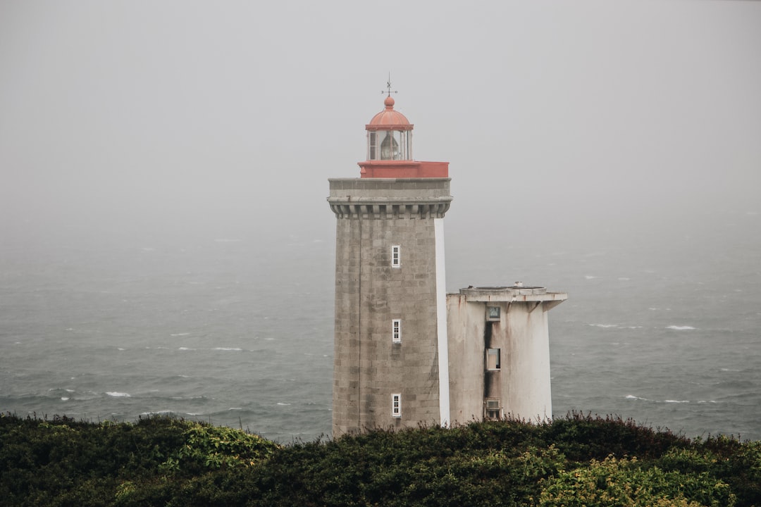 grey concrete lighthouse near seashore during daytime