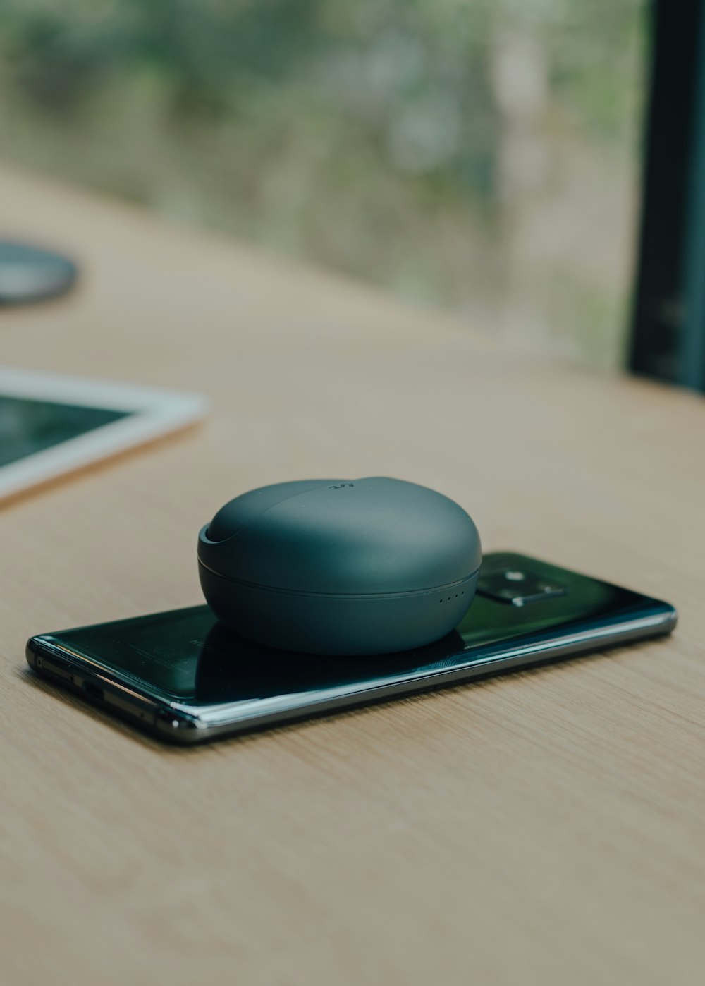 runder schwarzer kabelloser tragbarer Lautsprecher auf Android-Smartphone