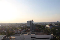 A panoramic cityscape showcasing a mix of commercial and residential buildings at sunset.