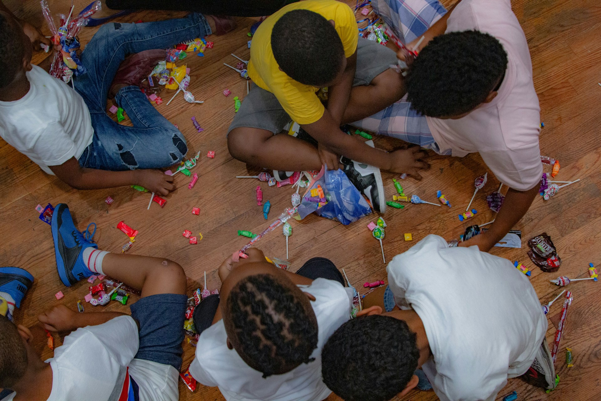 boys eating candies while sitting on floor