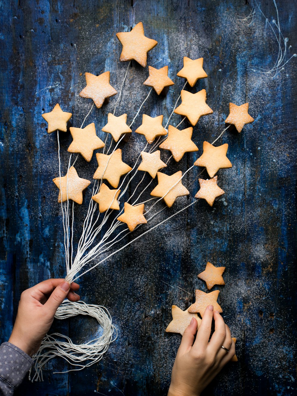 a person holding a bunch of star shaped cookies
