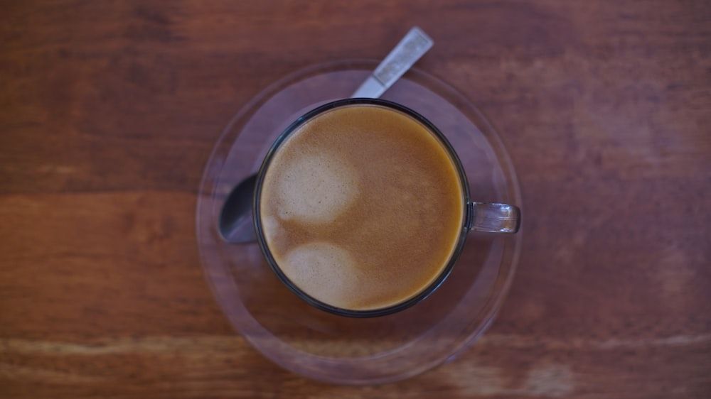 clear glass coffee cup with saucer