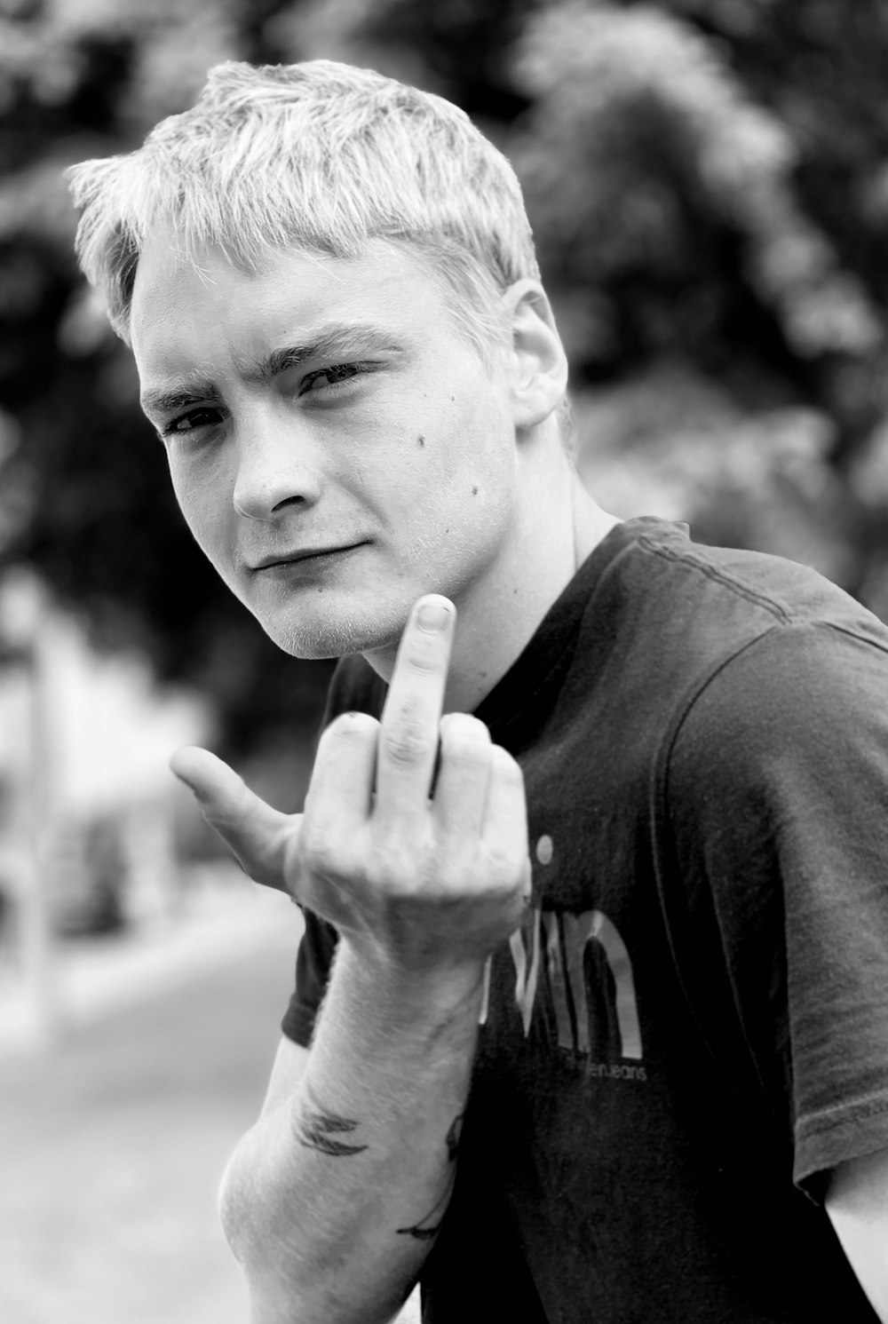 grayscale photo of man showing middle finger