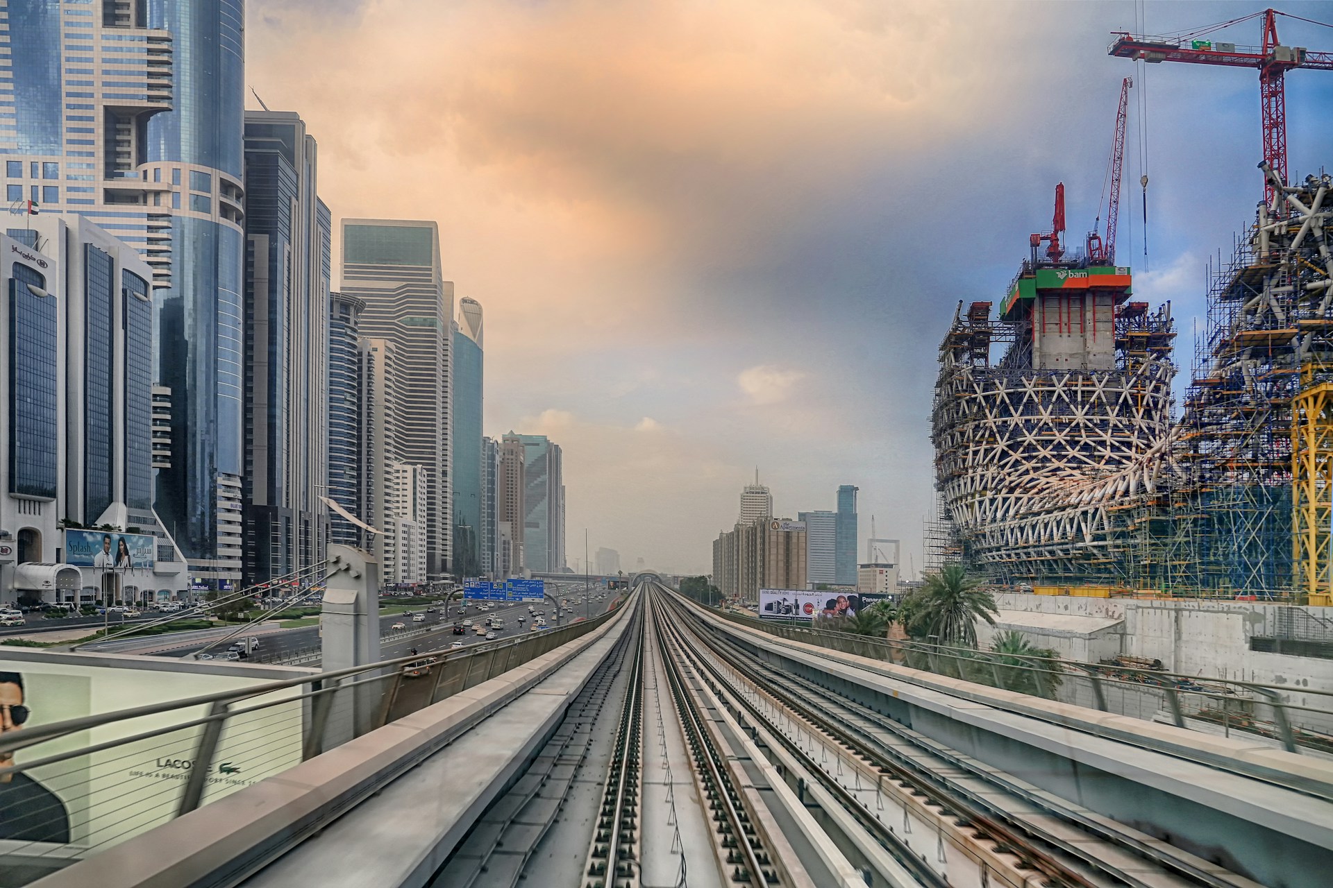 Futuristic construction site with humanoid robots collaborating alongside workers, set against a sleek black and white cityscape.