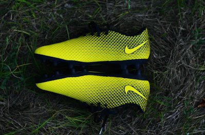 Shiny black and gold shin guards arranged neatly on a white background.